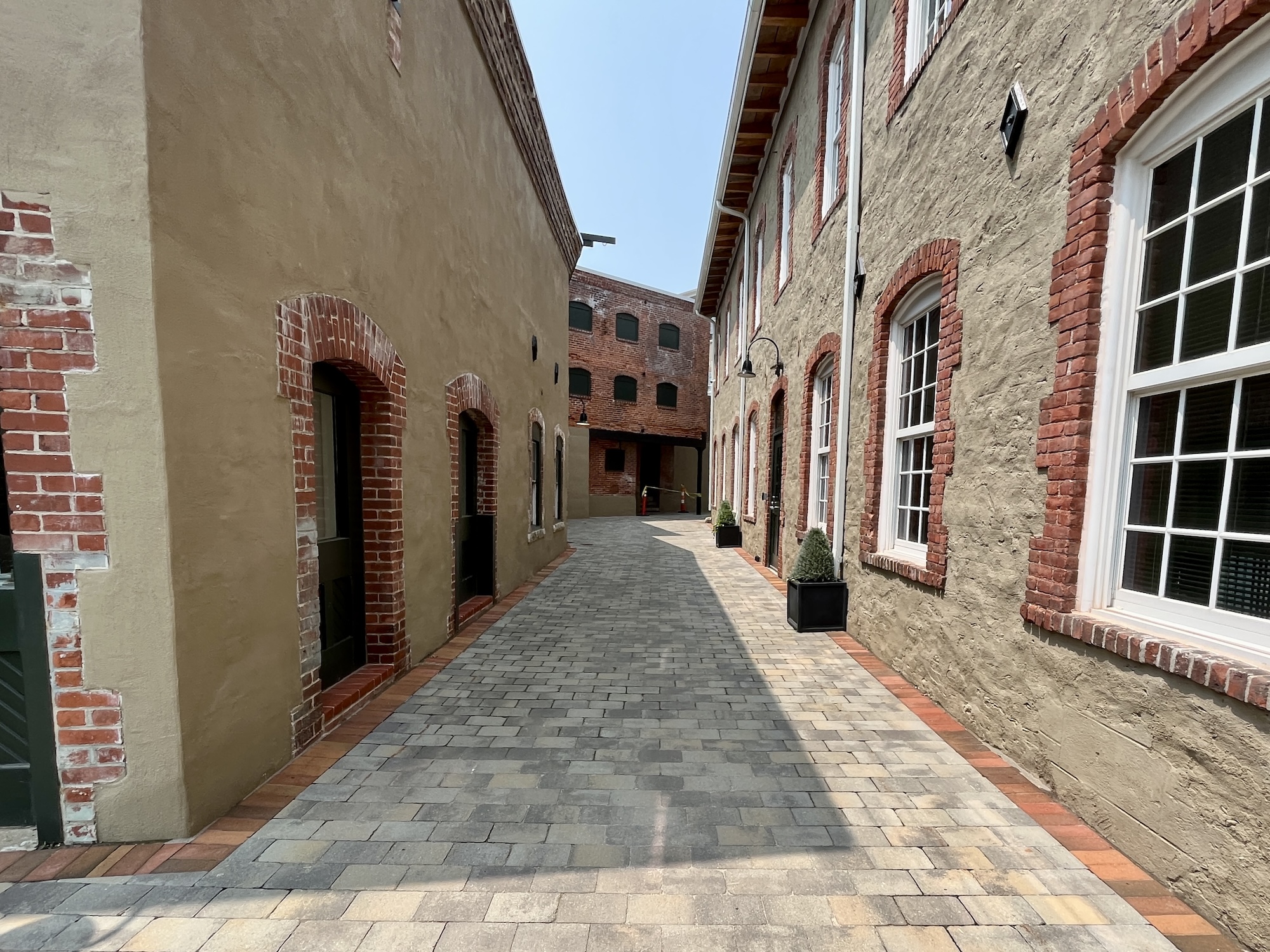 The winding corridor between the narrow stucco buildings of Pontiac Mills, known as The Mews